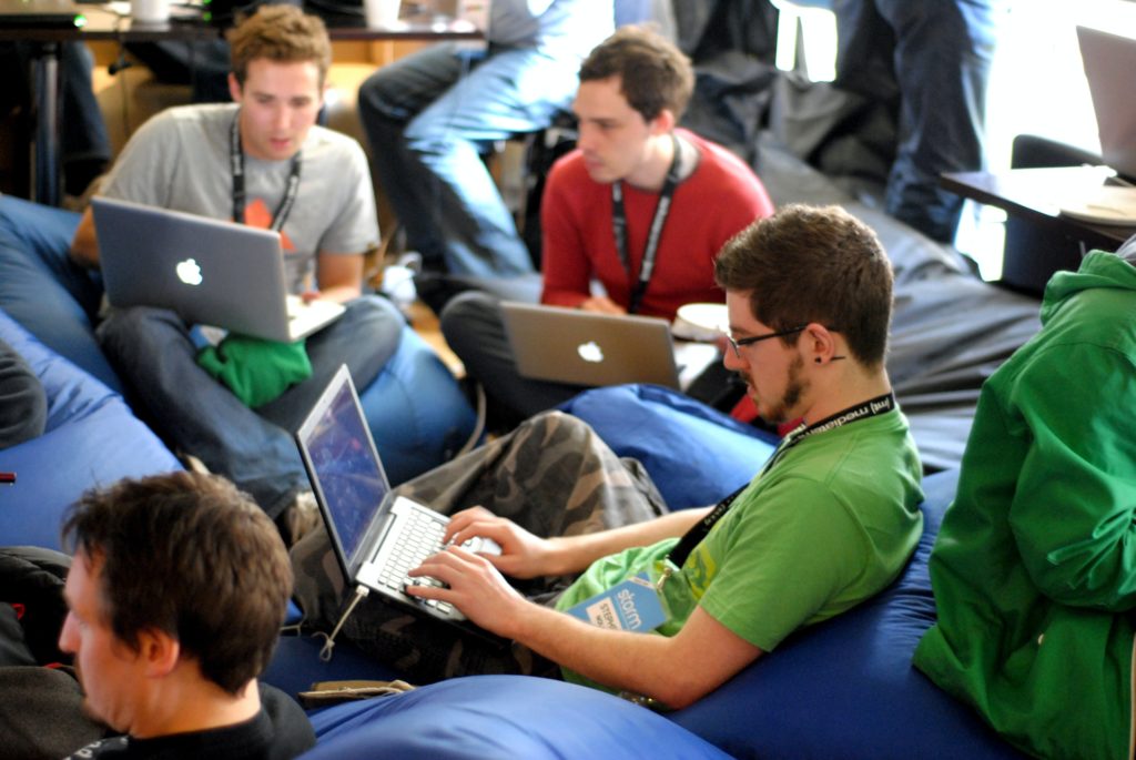 A group of young people seating on bean bags and wearing lanyards.